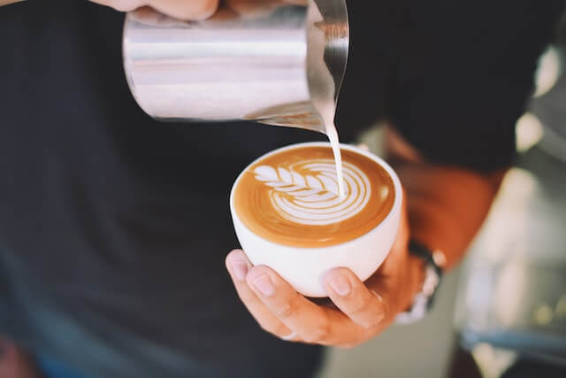 A hand holding a cappuccino