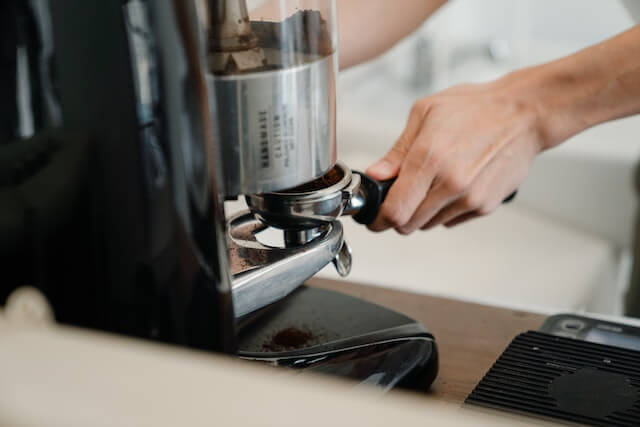 Person preparing coffee with machine