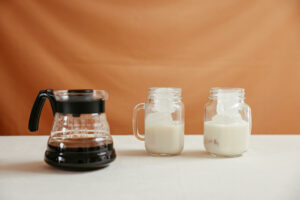a pot of coffee beside jars with iced milk
